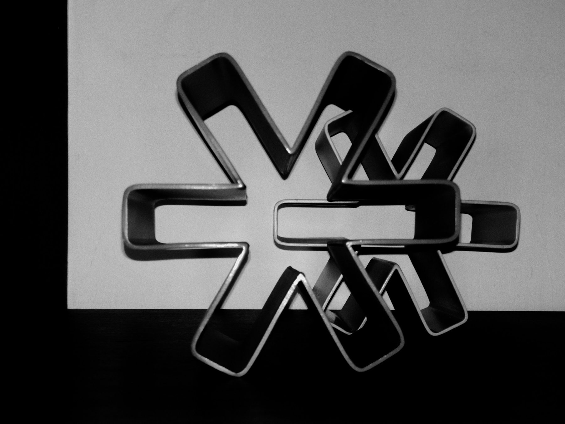 Escultura de asterisco en metal, fotografía en blanco y negro