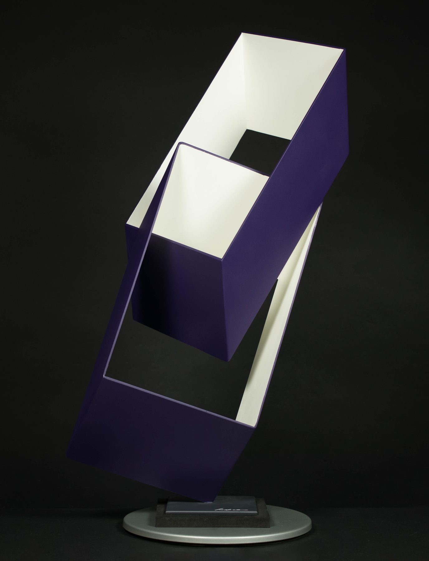 Escultura geométrica en morado y blanco, formas entrelazadas