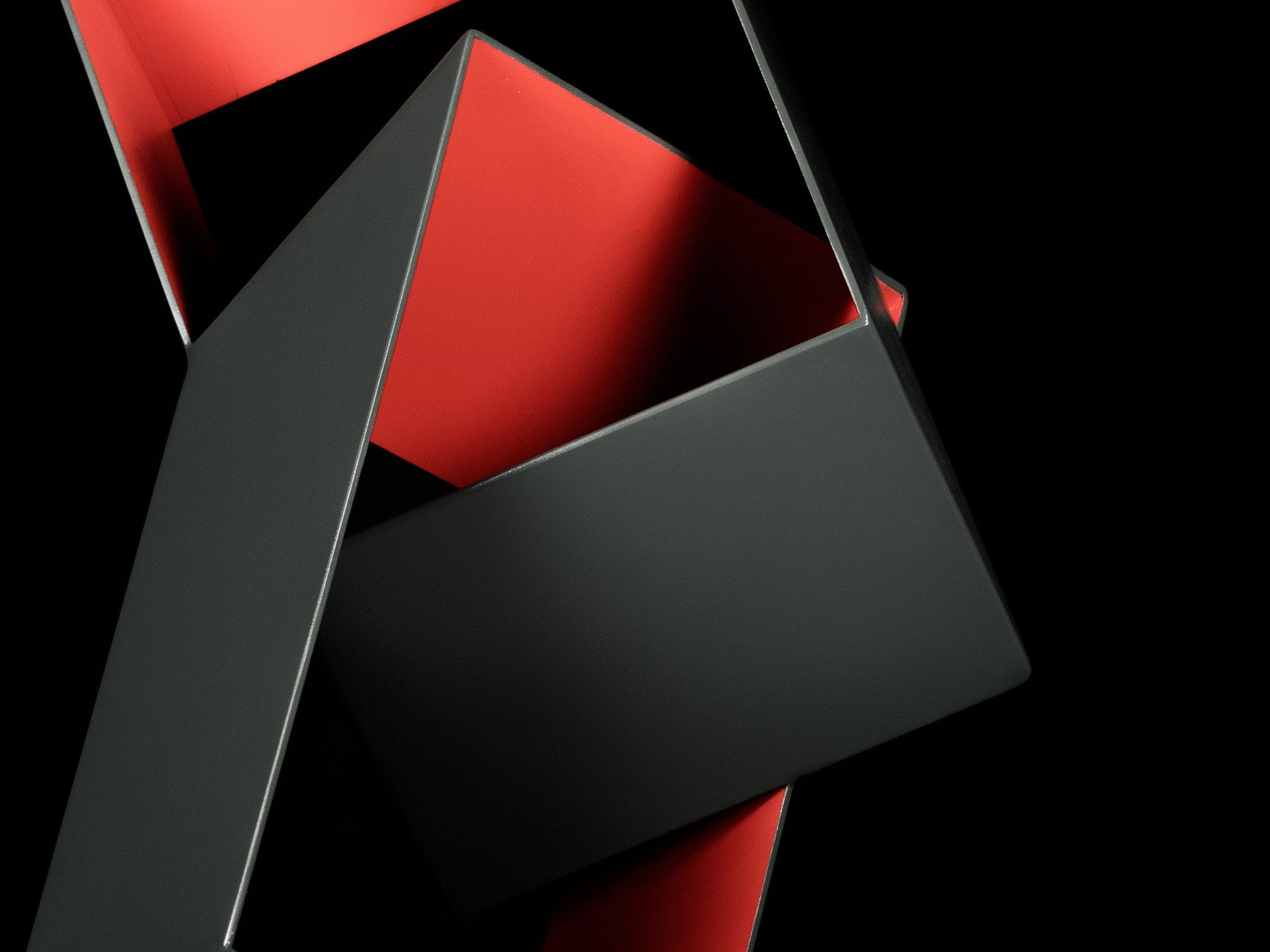 Detalle macro de una escultura geométrica en negro y rojo