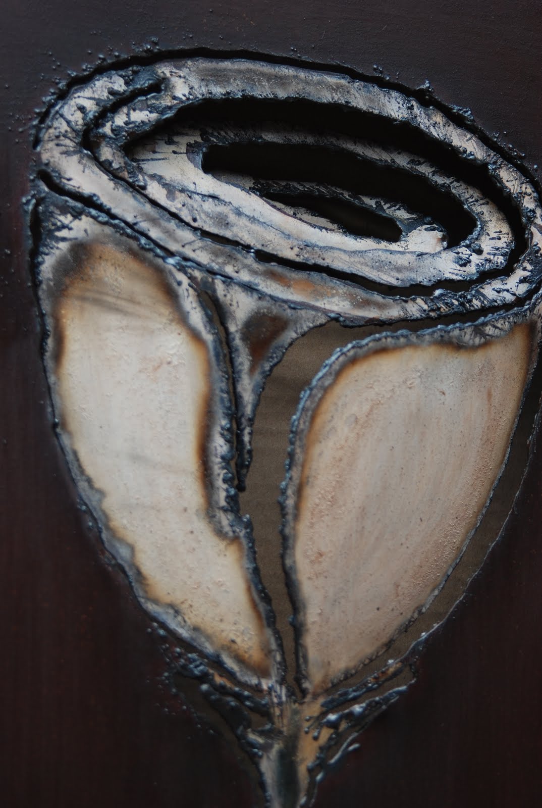 Escultura de flor en espiral de hierro sobre base de madera