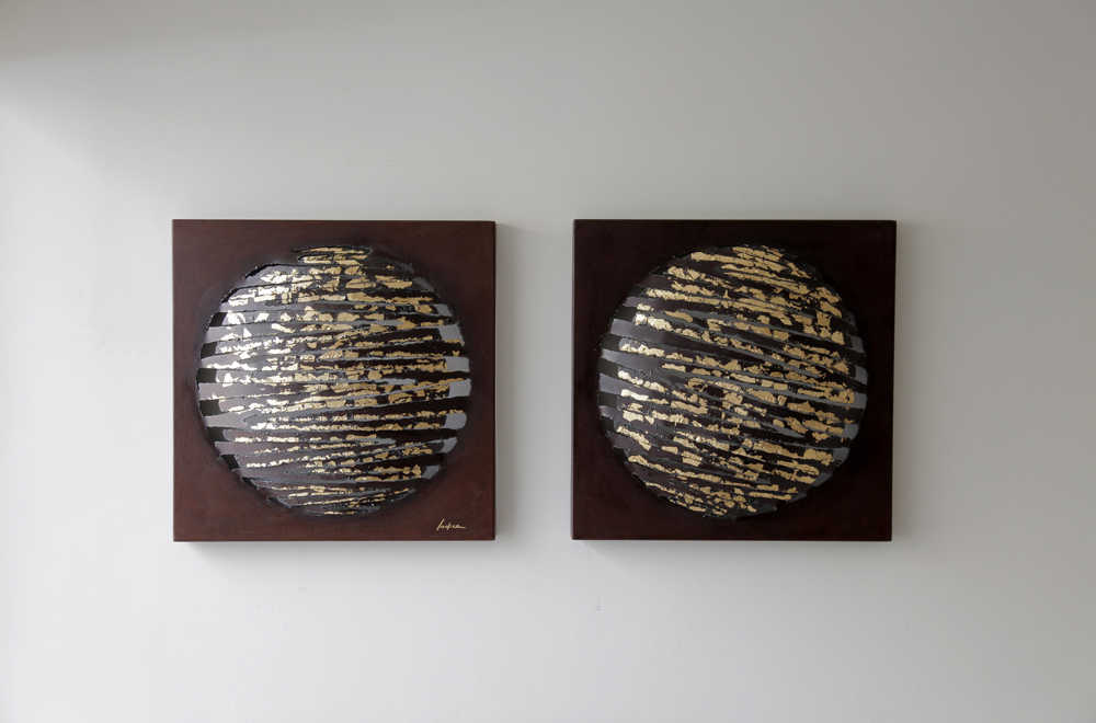 Dos esculturas de la colección Planetas montadas juntas en una pared