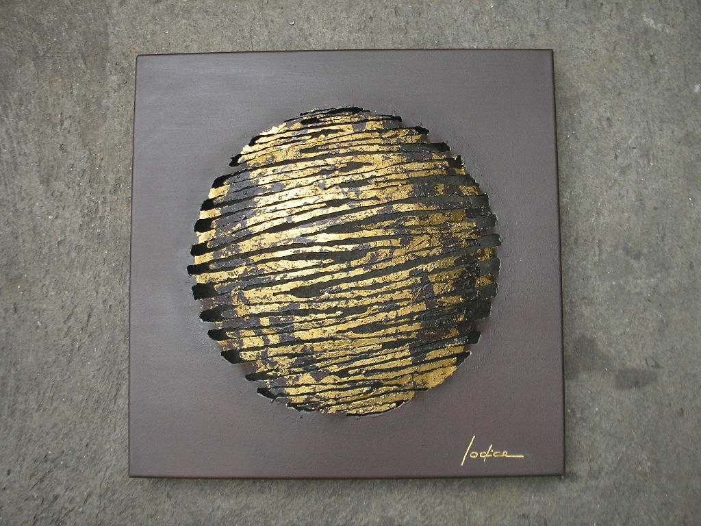 Escultura circular tipo planeta en hierro y pan de oro, sobre suelo de concreto