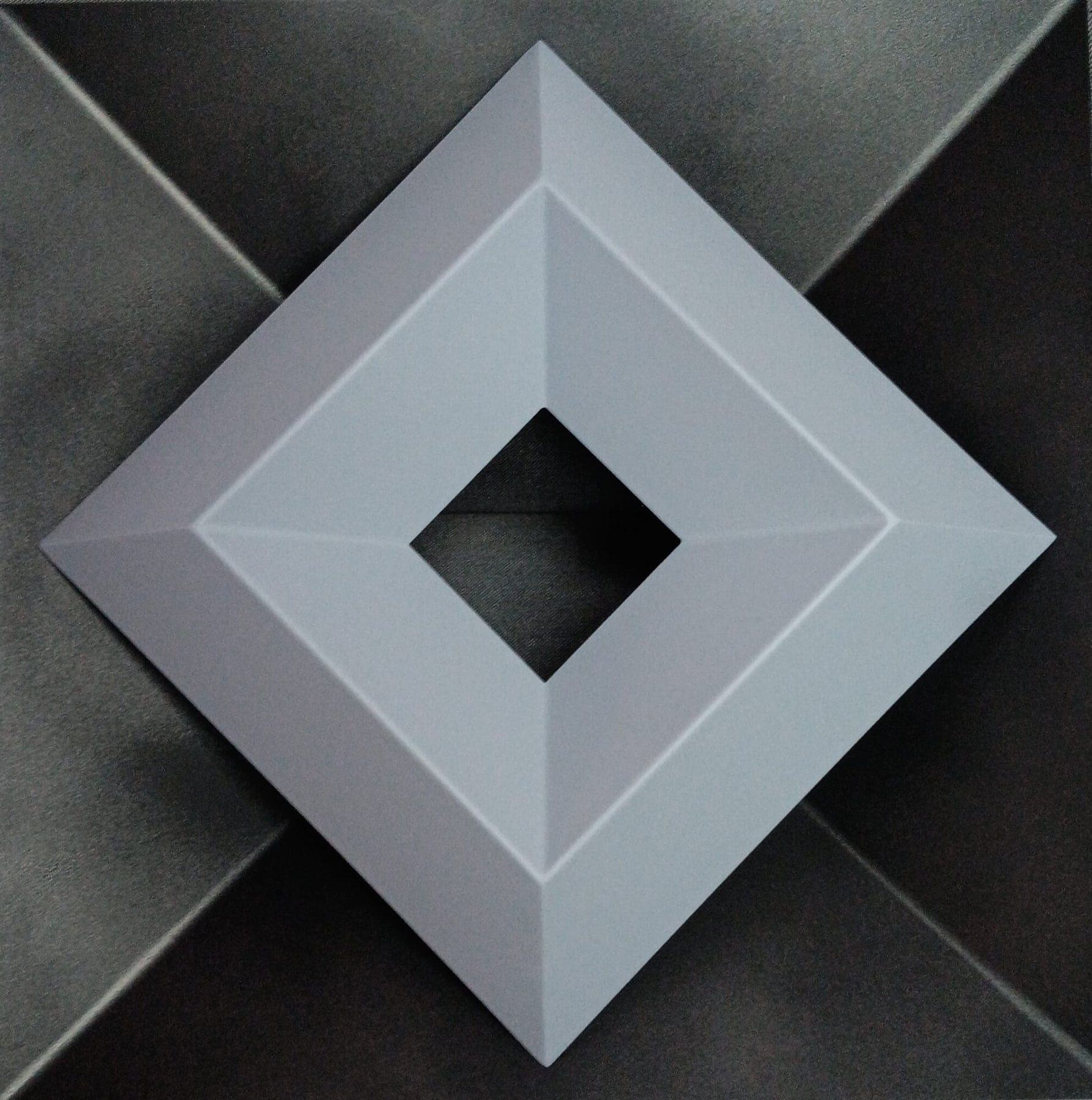 Detalle de una escultura de marco geométrico en gris